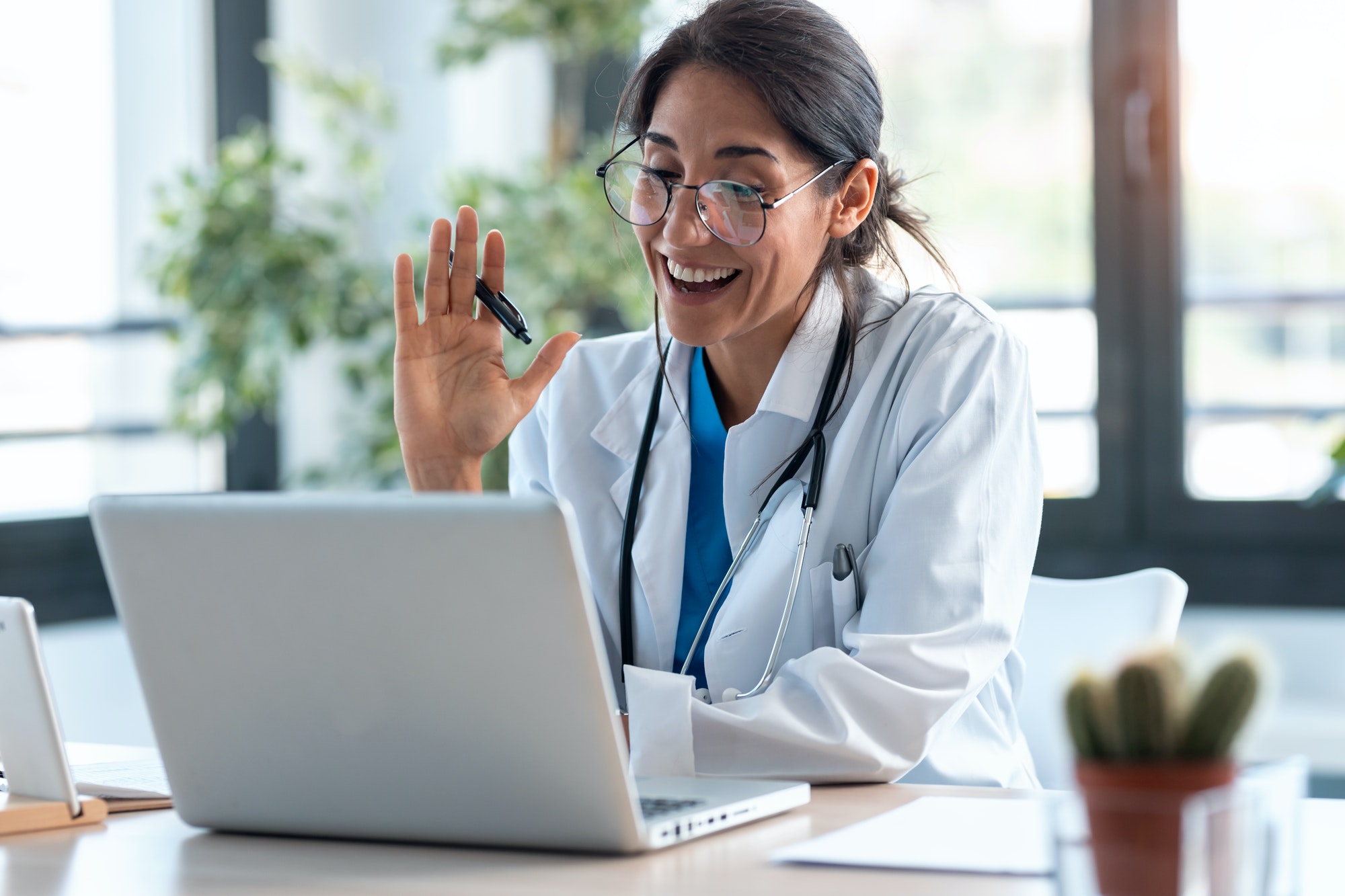 female-doctor-waving-and-talking-with-colleagues-through-a-video-call-with-a-laptop.jpg female-doctor-waving-and-talking-with-colleagues-through-a-video-call-with-a-laptop.jpg